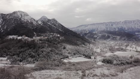 AERIAL---Village-of-Virpazar-in-snowy-winter,-mountains,-Bar,-Montenegro,-forward