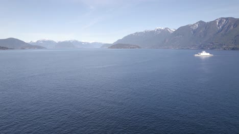 Vista-Aérea-De-Un-Barco-De-Los-Servicios-De-Ferry-De-Columbia-Británica-En-Vancouver,-Navegando-En-El-Agua-Del-Océano-En-Las-Montañas-Del-Paisaje-Natural-Canadiense-Durante-Un-Día-Soleado