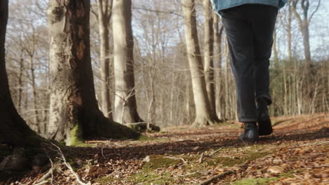 young-man-walking-on-the-forest-floor-next-to-trees
