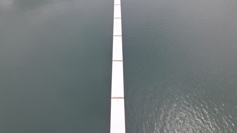 Aerial-dolly-in-top-down-of-pier-and-deck-in-calm-sea-near-the-coast-of-Nacascolo-beach,-Papagayo-Peninsula,-Costa-Rica