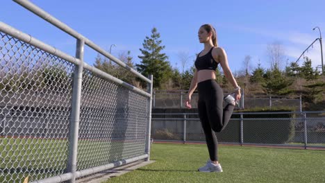 Young-athletic-woman-stretching-hamstrings-before-run-Wide-shot