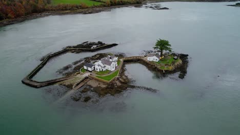 Aerial-view-rising-tilt-down-over-Ynys-Gored-Goch-houses-on-Whitebait-island-Welsh-flowing-Menai-Straits-Anglesey