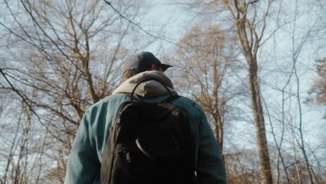man-walking-in-the-forest-with-backpack-on