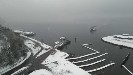 A-Washington-state-ferry-emerges-from-the-fog-and-a-snowstorm-to-dock-at-the-terminal,-aerial