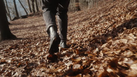 Mann-In-Stiefeln,-Der-Auf-Waldboden-Geht-Und-Viele-Blätter-Herumwirbeln