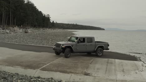 Drone-shoot-of-a-Grey-Jeep-Gladiator-on-the-beach,-in-4K