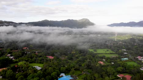 Low-clouds-above-town-of-Valle-de-Anton-in-central-Panama-located-inside-extinct-volcano-crater,-Aerial-wide-angle-flyover-shot