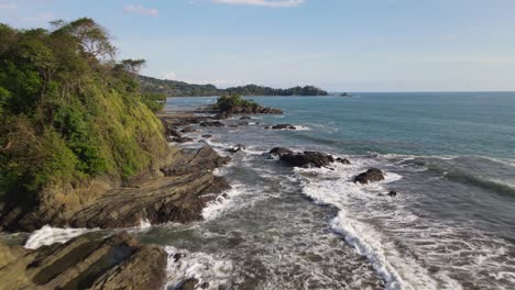 Drone-flying-over-sea-waves-crashing-on-rocks-on-coast-of-Costa-Rica