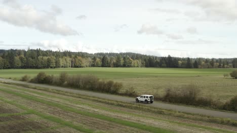 Drone-actively-following-a-White-Jeep-Wrangler-on-a-country-road-in-4k