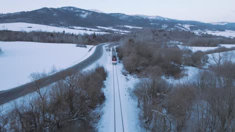 aerial-scenic-winter-snow-covered-landscape-train-driving-fast-through-remote-woodland-forest-in-tatra-national-park-in-Slovakia