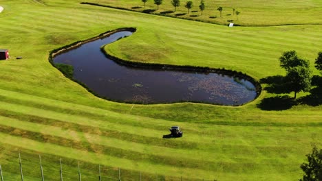 Electric-car-driving-on-green-field-with-water-obstacle,-Hills-Golf-Club-in-Molndal-near-Gothenburg