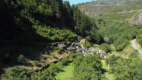 Toma-Aérea-De-Un-Pequeño-Pueblo-En-El-Valle-De-Las-Verdes-Montañas-De-Asturias,-España
