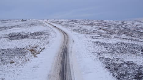North-York-Moors,-road-near-to-the-Lion-Inn-Blakey-Ridge-covered-in-heavy-snowfall-difficult-driving-conditions-in-winter-snow---aerial-footage-dji-inspire-2-CLIP-2