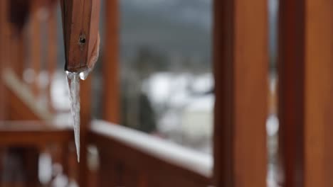 Sharp-Icicles-or-stalactite-frozen-hanging-on-wooden-balcony,-Close-up