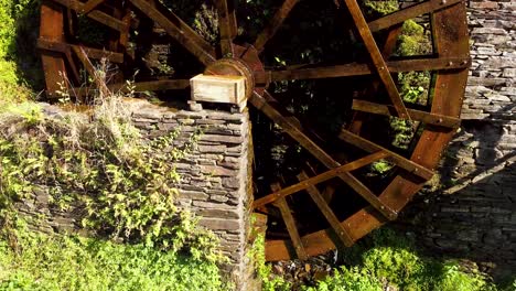 Old-big-water-mill-wheel-spinning-next-to-a-big-stone-wall