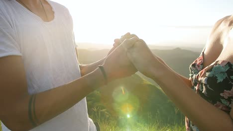 Male-and-female-couple-holding-hands-during-sunset-in-Valle-de-Anton-volcano-crater-Panama,-Close-up-orbit-right-shot