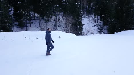 Hombre-Solitario-Con-Barba-Completa-Caminando-Lentamente-En-La-Nieve-Durante-El-Día,-Mirando-Alrededor-Y-Sonriendo