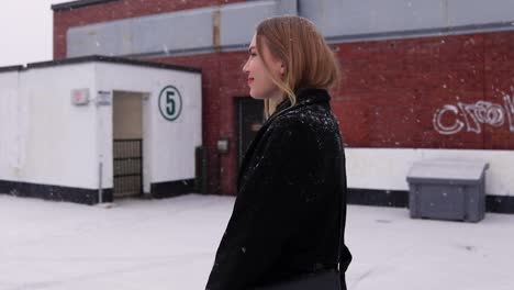 Schöne-Junge-Blonde-Frauen,-Die-Flirten,-Während-Sie-Auf-Einem-Parkplatz-Mit-Leichtem-Schneefall-In-Kanada-Spazieren-Gehen