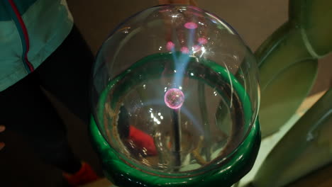 A-girl-puts-fingers-onto-a-plasma-ball-emitting-electrical-charge