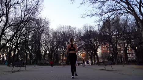 Young-Active-Female-Runner-Jogging-In-City-Park-From-Behind,-Full-Shot