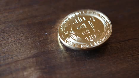 Gold-Bitcoin-wobbling-on-a-wooden-tabletop
