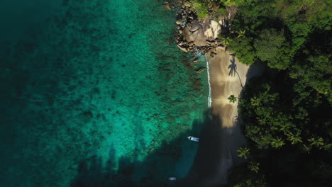 Slow-aerial-drone-footage-of-a-beautiful-white-sand-beach-and-blue-water-on-the-Seychelles-Islands