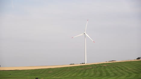 Single-windmill-on-meadow-in-summer,-static-camera,-clean-shot-with-copy-space