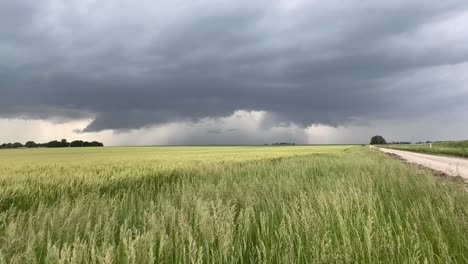 Gewitterwolken-Bauen-Sich-In-Der-Ferne-Auf-Einer-Landstraße-In-Kansas-Mit-Einem-Blitzeinschlag-Auf