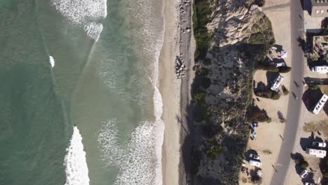 A-beautiful-aerial-drone-shot,-drone-flying-along-a-bicycle-lane-over-to-the-beach,-Carlsbad-State-Beach---California