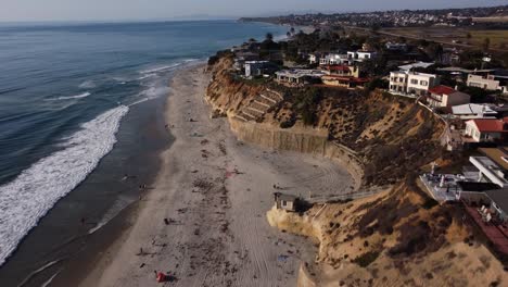 A-stunning-aerial-drone-shot,-flying-along-the-coastline-with-beautiful-beach-houses,-Solana-Beach---San-Diego---California