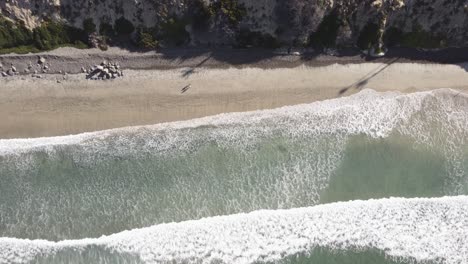 Una-Impresionante-Toma-De-Drones-Aéreos-Estáticos-A-Vista-De-Pájaro-De-Personas-Caminando-En-La-Playa,-Playa-Estatal-De-Carlsbad---California