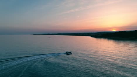 Ein-Einsames-Boot,-Das-Bei-Sonnenuntergang-In-Den-Dunklen-Gewässern-Segelt