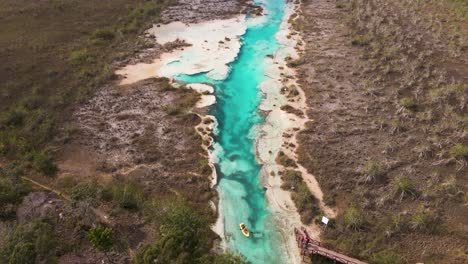 Upwards-panning-drone-shot-of-kayakers-revealing-the-scenic-view-of-"los-rapidos"-rapids-located-in-Bacalar,-Mexico-shot-in-4k