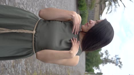 Beautiful-Latino-Hispanic-long-hair-woman-posing-with-green-dress,-outdoor-vertical