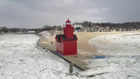 Holland,-Michigan-lighthouse-in-the-winter-at-Lake-Michigan-with-drone-flying-towards