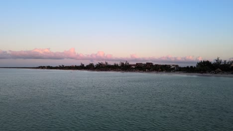 Weitwinkeldrohne,-Die-Während-Des-Sonnenuntergangs-Mit-Wunderschönen-Rosa-Farbtönen-In-Den-Wolken-Auf-Der-Tropischen-Insel-Holbox-Im-Karibischen-Meer-In-Mexiko-Aufgenommen-Wurde,-In-4k-Aufgenommen