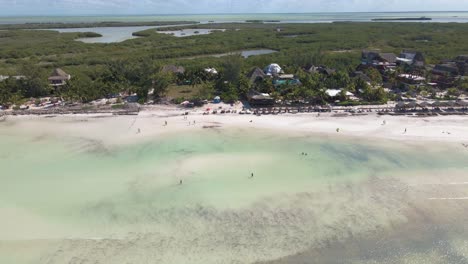 Wide-angle-drone-shot-panning-upwards-of-the-busy-white-sandy-beaches-off-the-coast-of-the-tropical-island-of-Holbox-in-Mexico-shot-in-4k