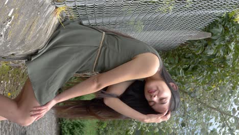 Pretty-Hispanic-Latino-girl-model-in-green-dress,-seductive-pose-smiling,-vertical