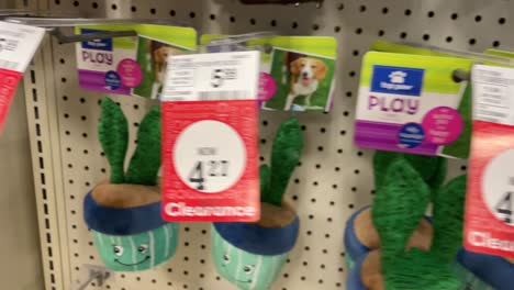 Dog-toys-squeaky-stuffed-animals-hanging-on-shelves-in-pet-store-for-puppies-and-playful-dogs-and-pets