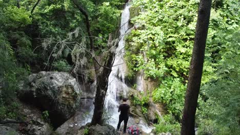 Kerl-Posiert-Und-Beobachtet-Den-Fallenden-Wasserfall