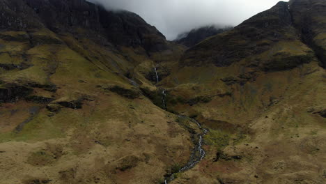 Aerial-shot-of-a-small-waterfall-located-in-the-GLENCOE-HIGHLANDS-VALLEY