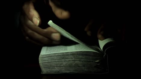 praying-to-God-with-hand-on-bible-black-background-with-people-stock-footage