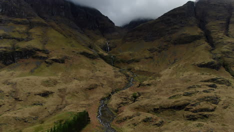 Filmische-Luftaufnahme-Eines-Kleinen-Wasserfalls-Im-Tal-Der-Glencoe-Highlands