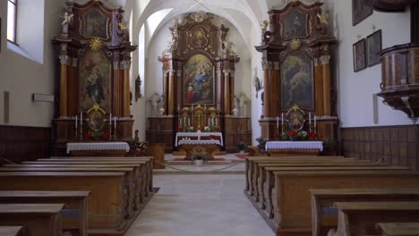 Moving-dolly-shot-of-the-interior-of-a-17th-century-Roman-catholic-church-in-San-Candido,-Italy