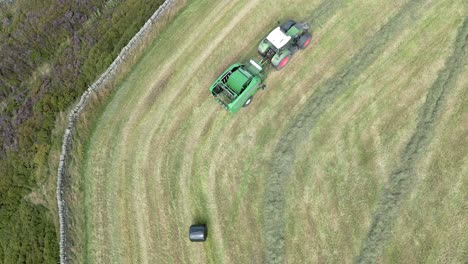 Aerial-scenery-of-harvesting-hay-using-a-tractor-landscape-at-rural-countryside