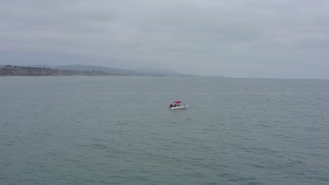 Eine-Schöne-Luftdrohnenaufnahme,-Die-Ein-Boot-Im-Ozean-Verfolgt-Und-Umkreist,-Dana-Point---Orange-County---Kalifornien