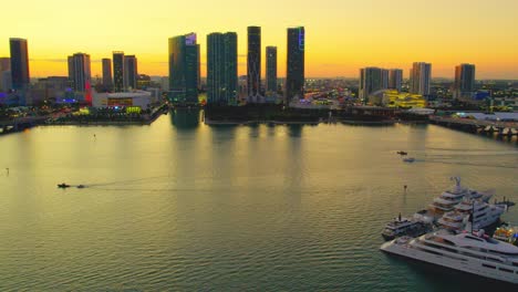 Aerial-video-of-yachts-at-a-miami-florida-marina-and-Miami-Skyline-during-sunset,-smooth,-luxury-with-pan-view