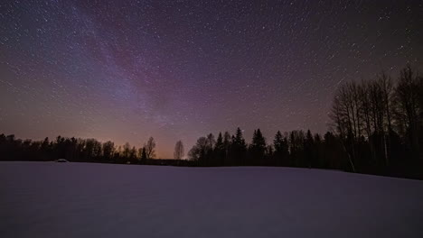 Verträumter-Nachthimmel-Im-Zeitraffer-Mit-Umkreisenden-Sternen-über-Verschneiten-Wäldern
