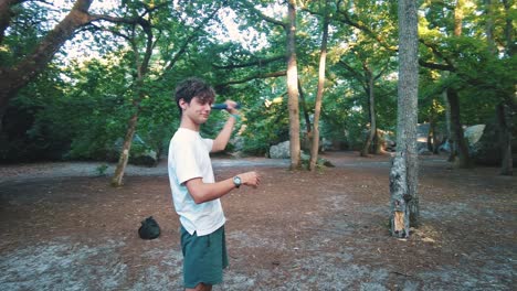 young-teenage-man-throwing-axe-into-tree-trunk-in-forest-in-fontainebleau-sport