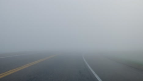 point-of-view-of-a-vehicle-driving-down-the-highway-in-low-visibility-due-to-foggy-weather-conditions
